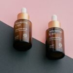 two bottles of gerania vitamin c - lift on a pink and black background